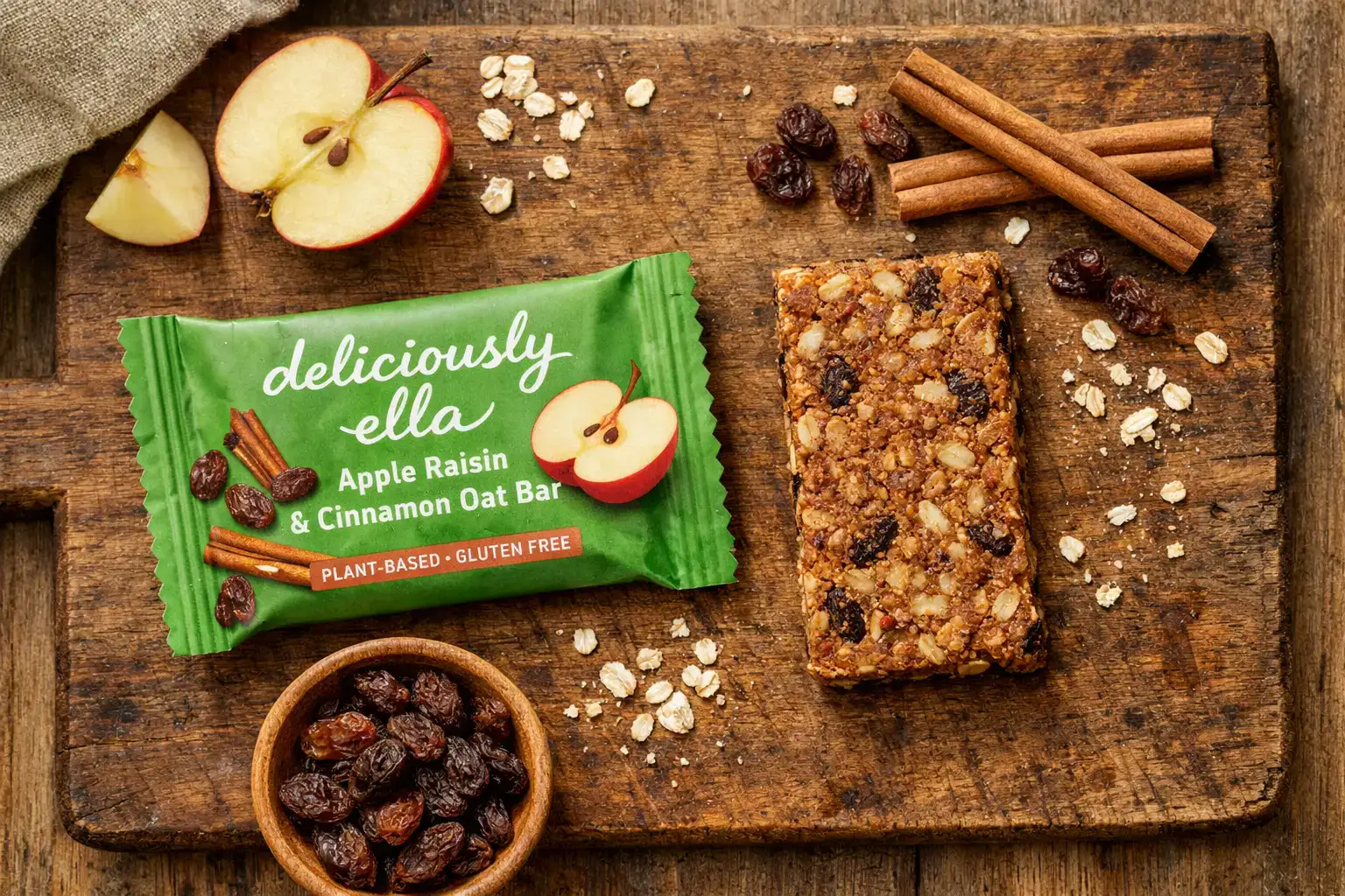 Barre d'avoine Deliciously Ella Pomme Raisin et Cannelle fraîche sur table en bois rustique – 213 calories par barre
