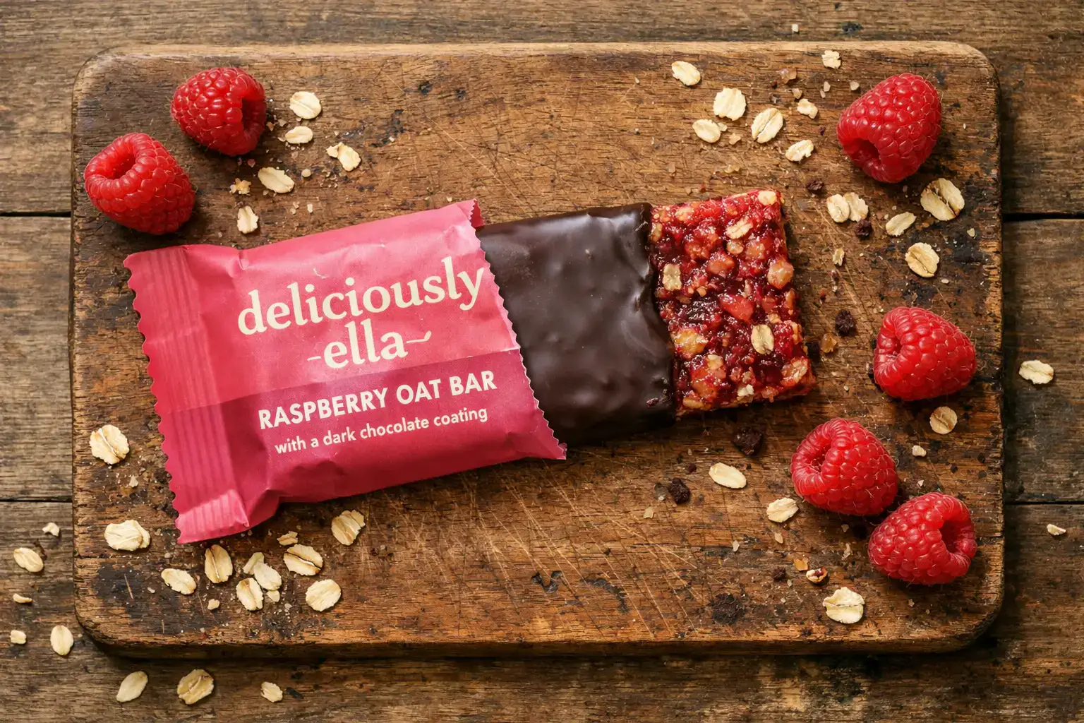Frischer Deliciously Ella Raspberry Oat Bar auf rustikalem Holztisch - 180 Kalorien pro Riegel