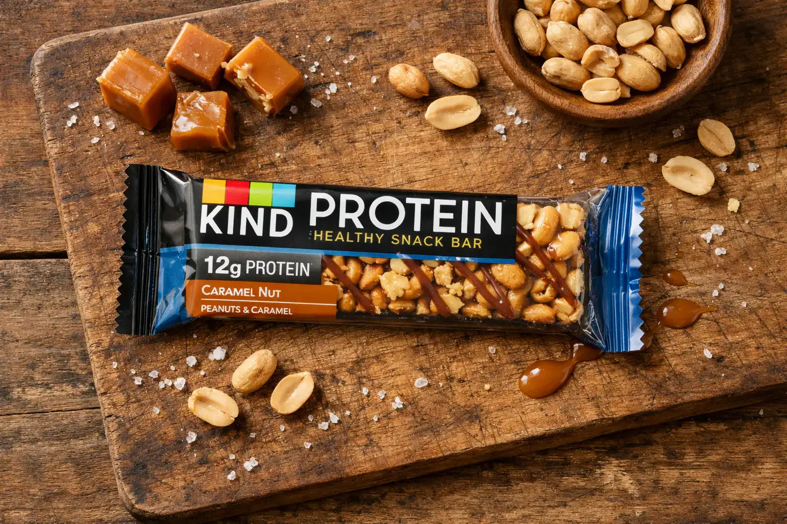 KIND Protein Max Sweet Salty Caramel Peanut bar on rustic wooden table - 240 calories per bar