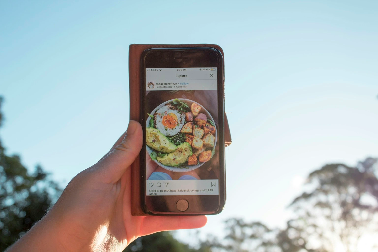 Person holding a smartphone, testing a new food tracking app side by side with the old one