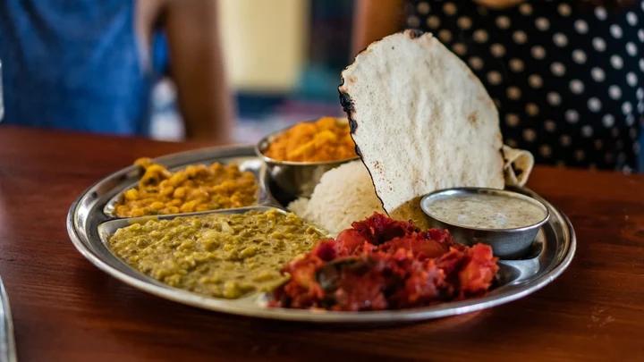 Traditional Indian thali with rice, flatbread, and curry dishes